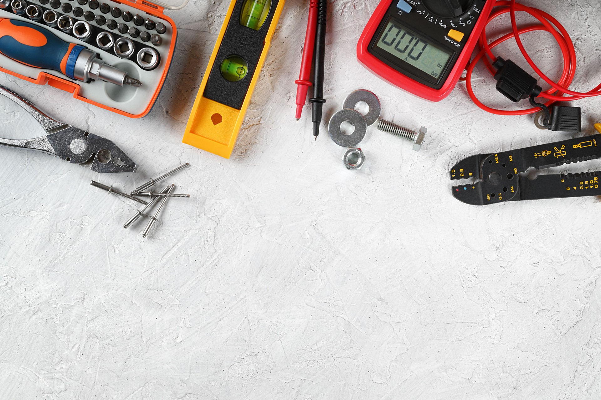 Set of hand tools on white plaster background. Work tools for electrician, carpenter, mechanic, plumber and hobbist. Top view, space for text, flat lay.