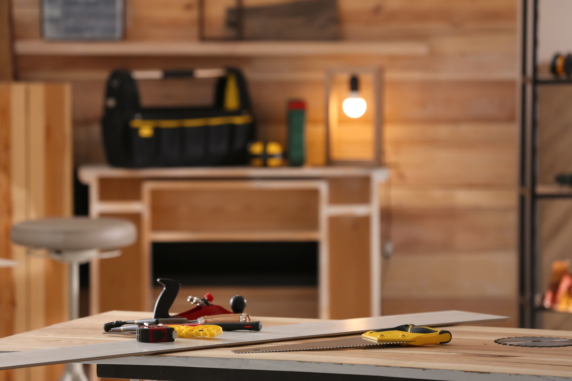 Different carpenter's tools on wooden table in workshop. Space for text